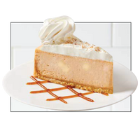 Slice of cheesecake with whipped cream and caramel drizzle